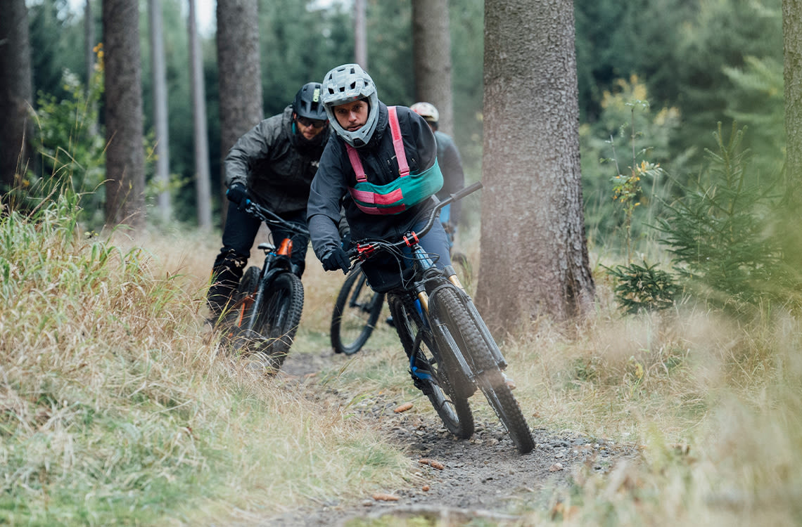 Marek riding mountain bikes with friends in the woods.