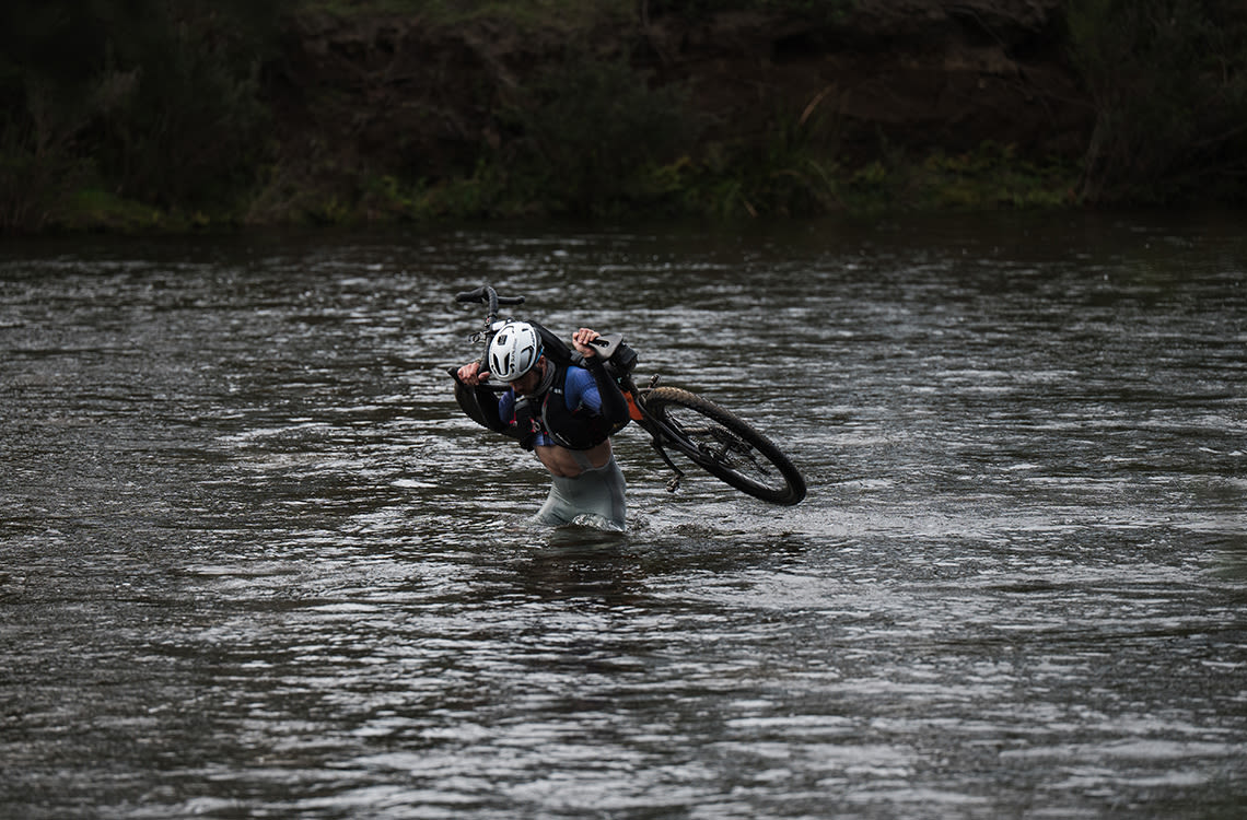 Scott carrying his XTC across a river crossing.