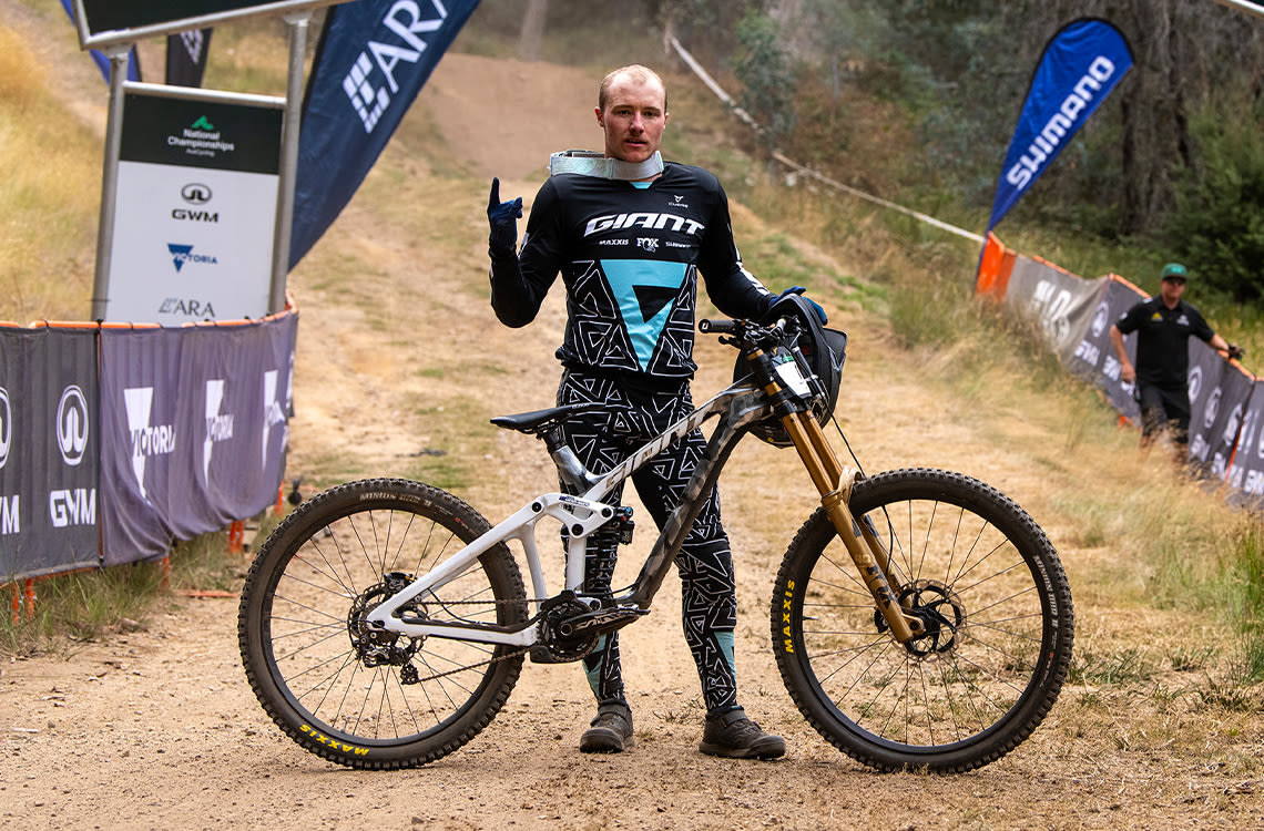 Luke Meier-Smith standing with his Giant Glory Advanced downhill bike.