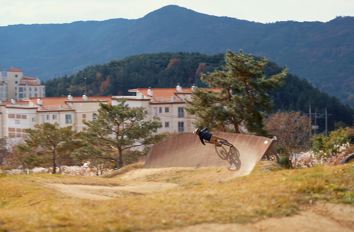 Mountain biker riding a wallride feature.