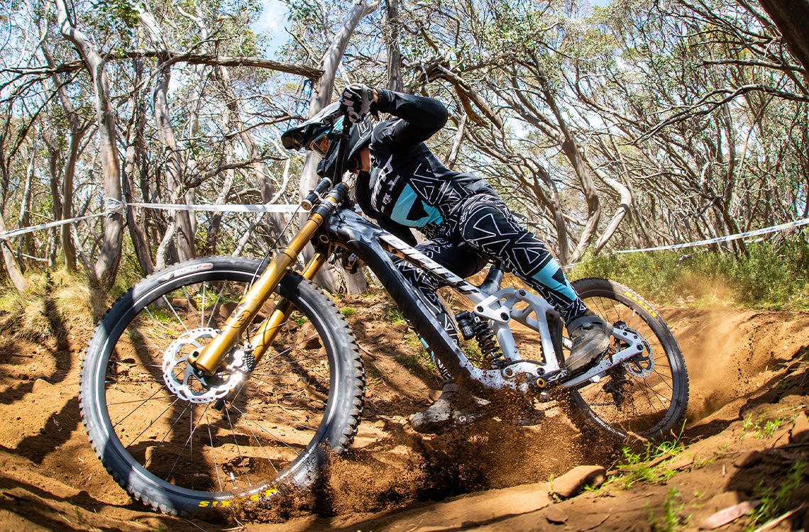 Mountain bike athlete Luke Meier-Smith racing through a sandy corner.