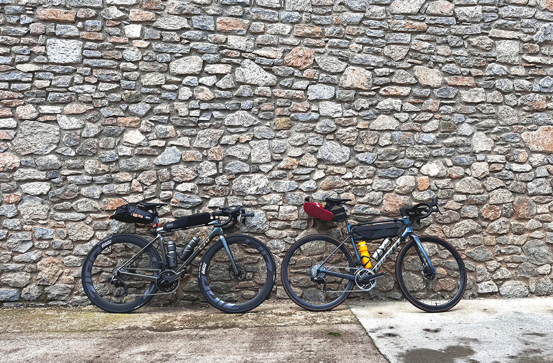 Two road bikes against a brick wall.