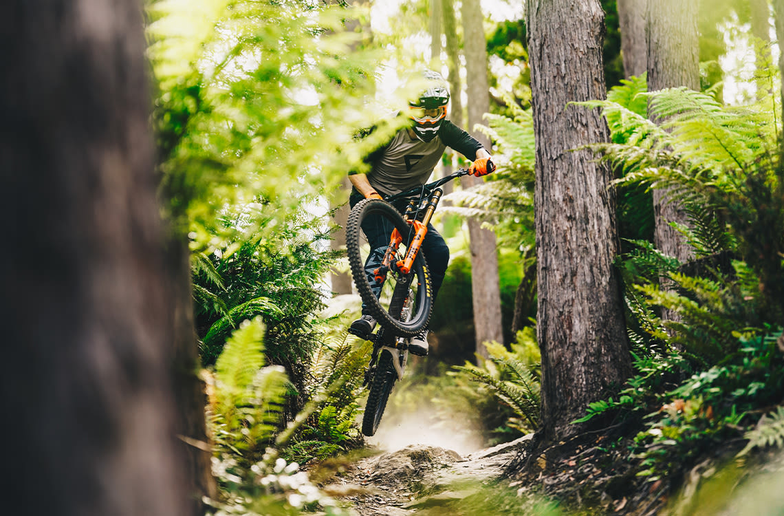 Mountain biker riding downhill bike in the woods.
