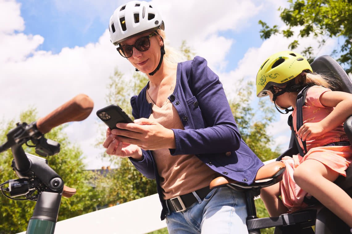 Woman looking at App while riding with child