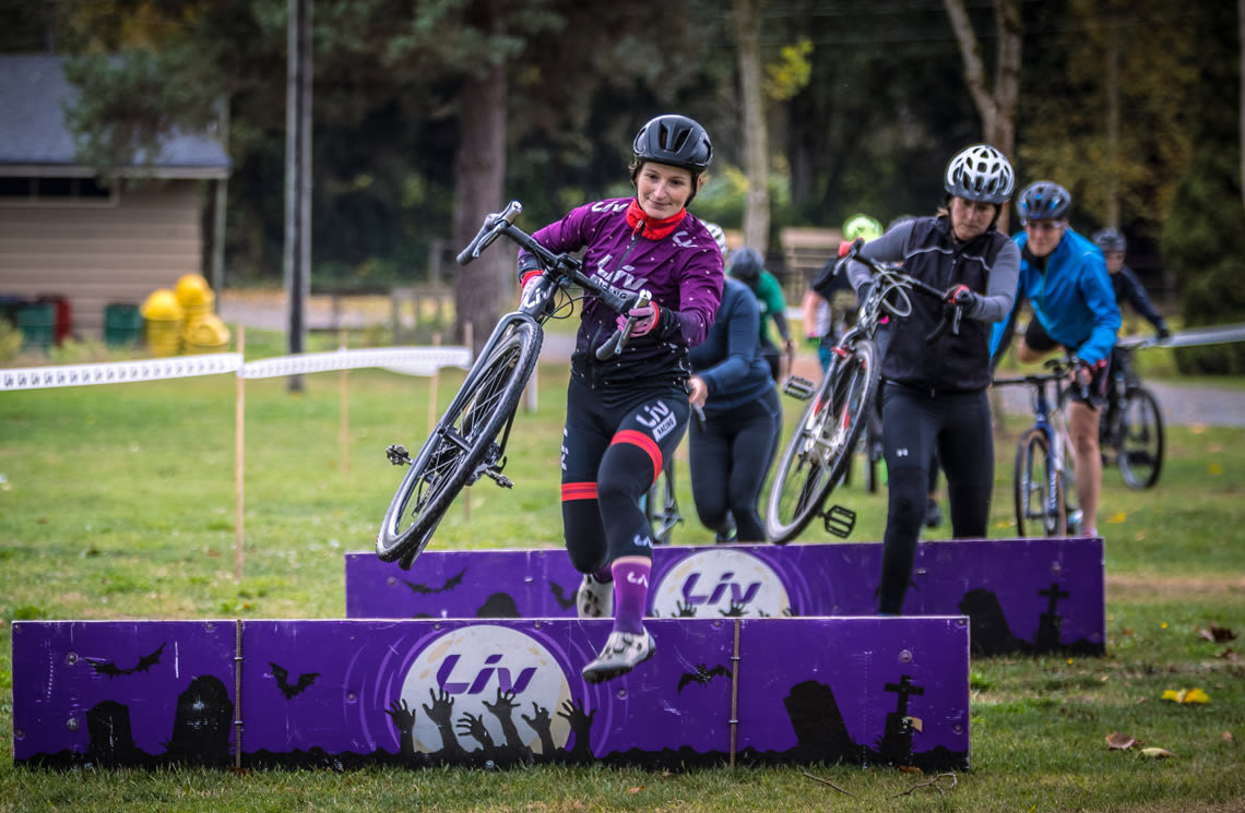 Sandra Walter leading a cyclocross clinic over barriers