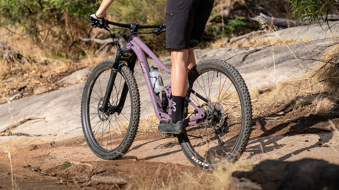 image of a woman riding a mountain bike down a dirt path