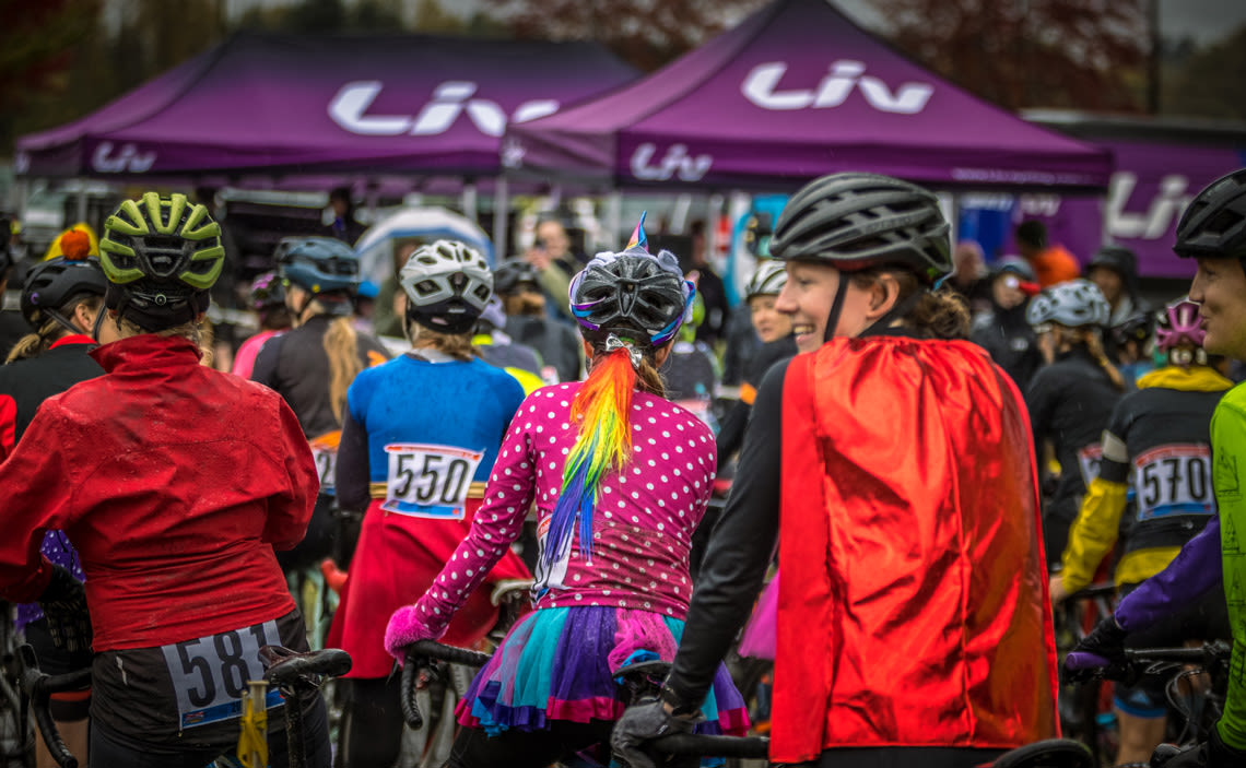 women lined up at the start of a cyclocross race, wearing festive attire