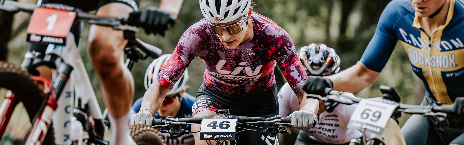 Ronja Blöchlinger doing a wheelie across the finish line on her Liv Pique mountain bike