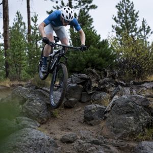 A cross country mountain biker rides through a rocky descent on a Giant Anthem Advanced SL with a Contact Switch SL dropper post.