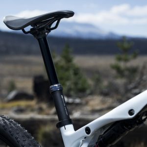 A close up look at the Contact Switch SL Dropper Seat Post on a Giant Anthem Advanced SL cross country mountain bike with a mountain background.