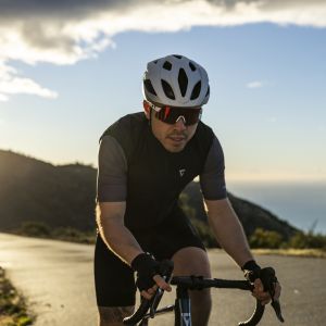Road cyclist approaches wearing Giant Rev Elite helmet.