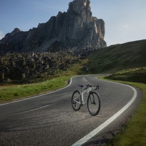 A drive side view of the Giant Seek youth road bike standing still on a sunny mountain road.