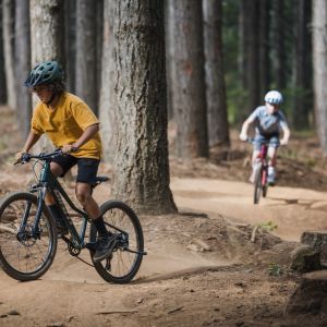 Kids mountain biker rider with friends riding on trails