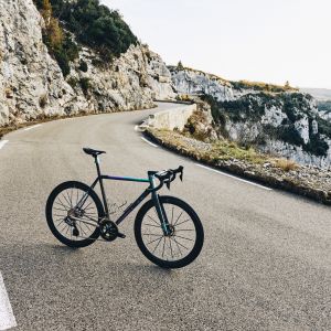 A high end custom titanium road bike staged on an alpine road with CADEX whels mounted with CADEX Aero Tires.