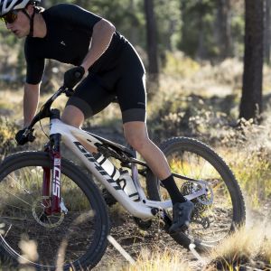 A mountain biker riding a Giant Anthem Advanced Sl with Giant XCR wheels rips through a corner on a trail.