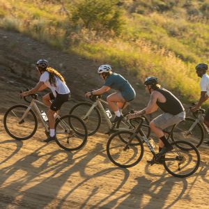 group of four road cyclists on a dirt climb