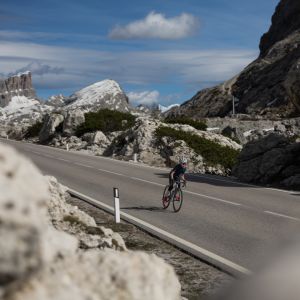 A young cyclist rides through a high mountain pass on a Giant Seek Road bike.