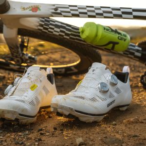 The Giant Charge Pro gravel/XC shoes sitting in front of a Giant Revolt Advanced SL gravel bike. 
