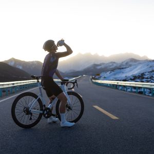 Road cyclist enjoying water over his road bike