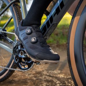 A close up look at a cyclist wearing Giant Charge gravel shoes resting on the side of the trail.