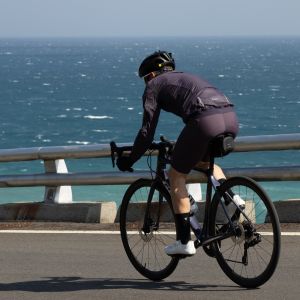 Cyclist descending on ocean road with Giant Shadow Seat Bag.