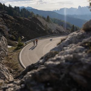 A father and son ride Giant road bikes through the mountains.