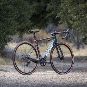 Drive side of the Giant Defy Advanced E+ Elite AR at an angle on a dirt road.