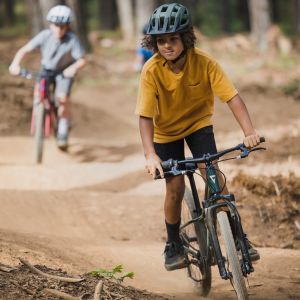 Young teenager riding with friends on kids mountain bikes