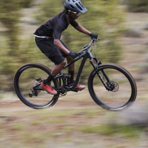 Mountain biker pedals by on slight uphill riding Giant Trance with Crest FloTrac TR shock.