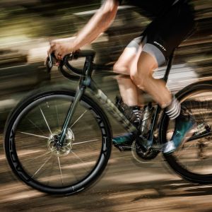 A cyclist riding a Giant Defy road bike with Cadex Ultra 40 wheels.