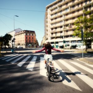 A cyclist rides her Liv Tempt E+ EX through the city and takes a moment to coast with her hands off of the bars.