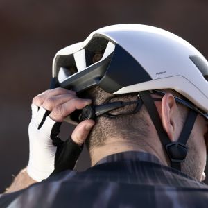 A cyclist adjusts their Giant Pursuit Helmet using the boa dial on the back.