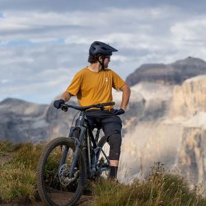A mountain biker rests on their Giant Trance Advanced E+ trail mtb with Giant TRA HD wheels.