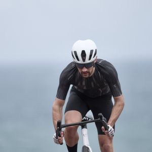 A cyclist ascends out of the saddle riding a Giant Propel Advanced Pro and wearing a Giant Pursuit Helmet.