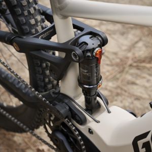 A close up look at the rear suspension on a Giant Stance E+ electric trail bike staged out on a trail.