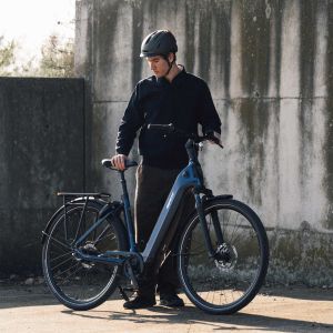 A cyclist stands next to their Giant NewTour E+.