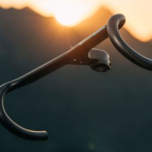 A side look at the CADEX Aero Integrated Road Handlebar floating in front of a mountain backdrop.