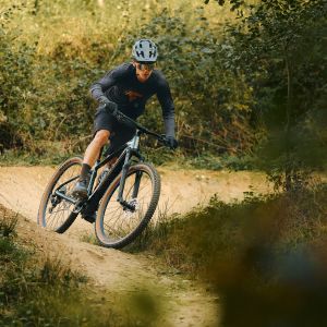 A mountain biker riding a Giant Talon E+ mtb rides through a chicane. 