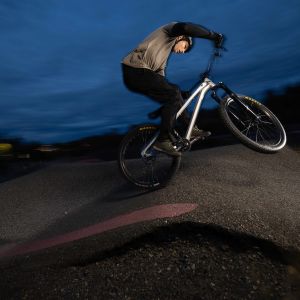 A rider catches a little air off a roller at a bike park on a Giant STP 26 dirt jumper.