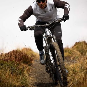 A mountain biker descends at speed down a mountain trail on a Giant Reign Advanced E+.