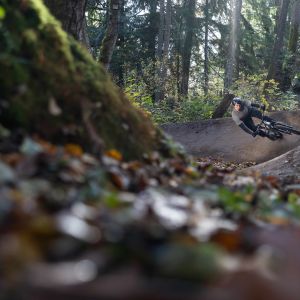 A rider comes through a steep berm on a forest trail riding a Giant STP 26.