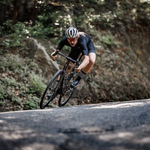 A road cyclist on a Giant defy with Cadex Ultra 40 wheels rips through a mountain descent at speed.