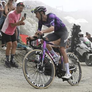 A Giant Jayco Alula pro rider ascends a high mountain dirt road at the Giro on a Giant TCR Advanced Sl team bike.