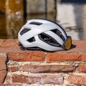 The Giant Rev Pro helmet sitting on a brick wall with sunglasses.