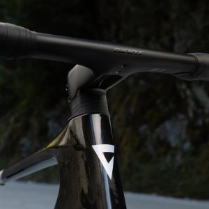 A close up look at the underside of the CADEX integrated handlebar mounted on the Giant Revolt Advanced SL on a dirt road in the woods.