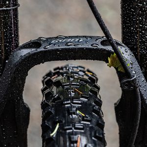 a closeup of a mountain bike fork and tire in the rain