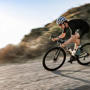 A cyclist descends a mountain road on their Giant road bike with Cadex Ultra 40 wheels.