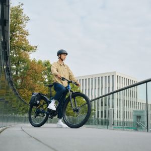 A cyclist rests on their Giant Talon E+ EX hardtail all road bike in the city.