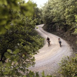 Cyclists riding electric touring bikes on gravel road