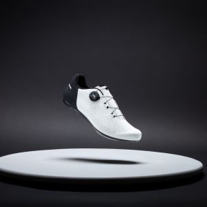 A side angled view of the Giant Surge 3 road bike shoe in the white/black colorway with a stylized studio background.